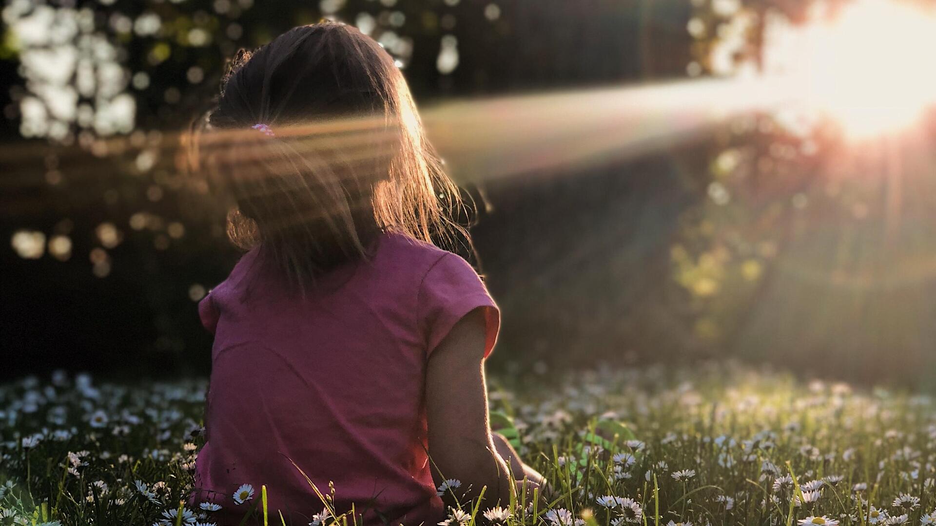 Kind im Wald mit Sonnenstrahlen